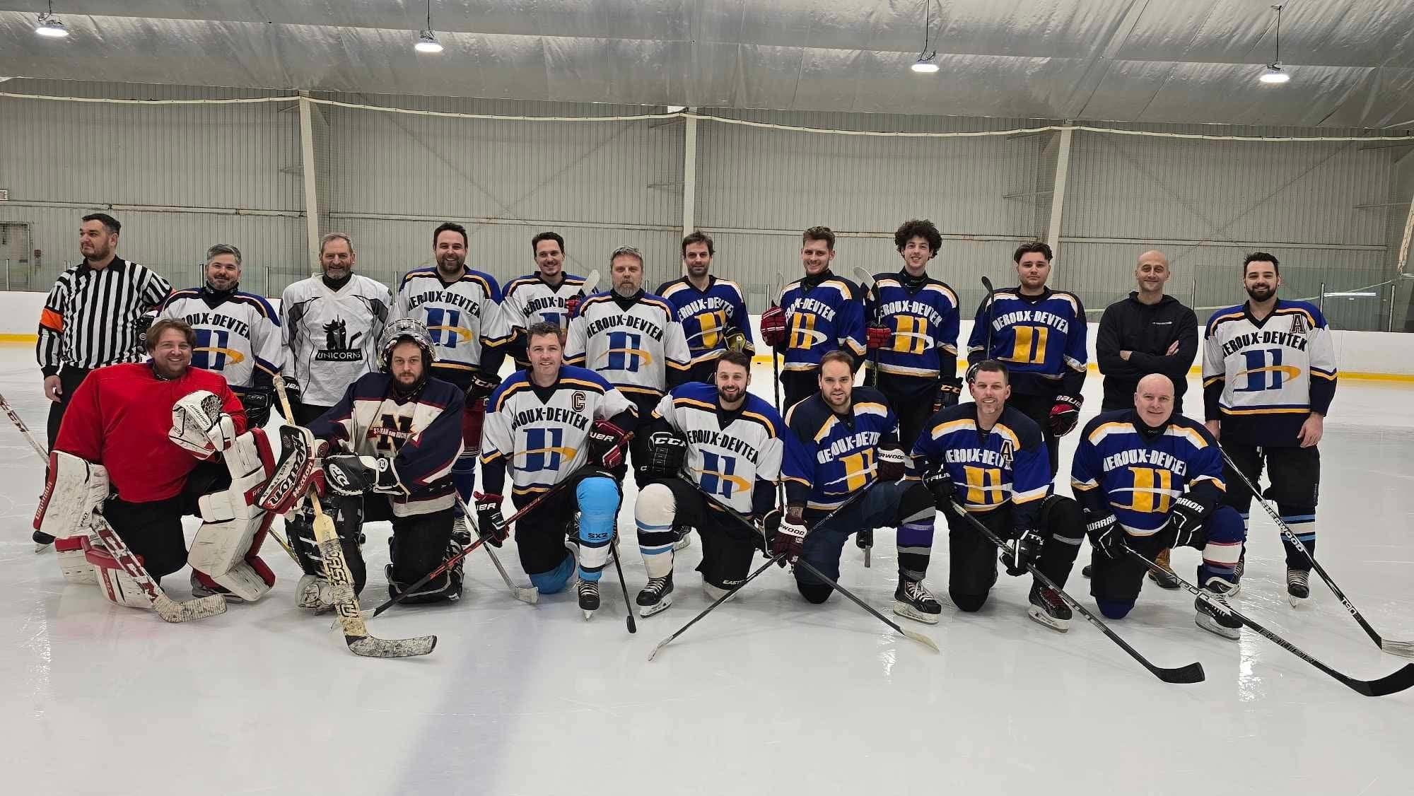 Heroux-Devtek team photo on the ice with the officiating crew